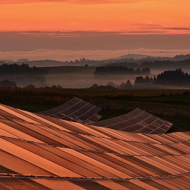 Solaranlagen im nebligen Sonnenaufgang