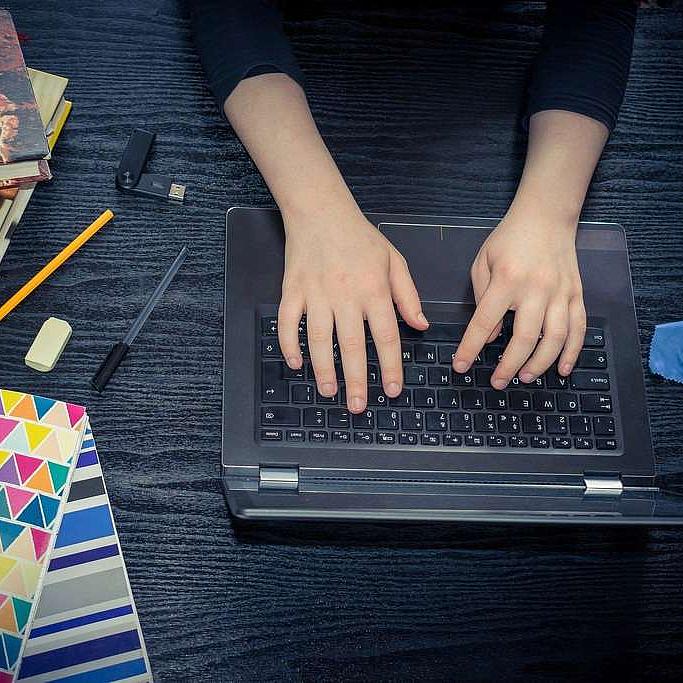 Hände auf einer Laptop-Tastatur